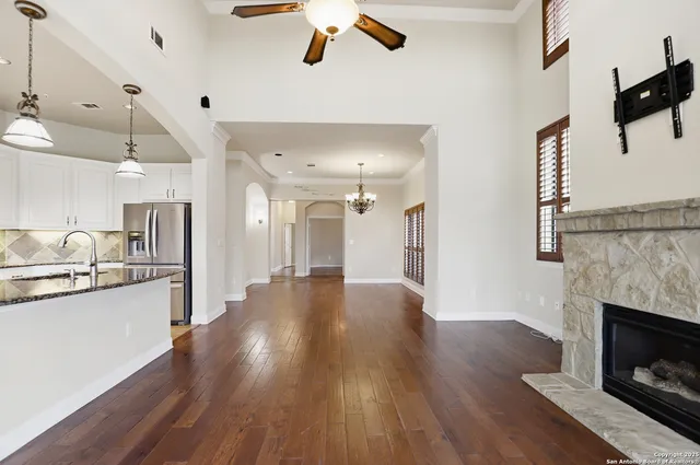 a view of a kitchen with a sink wooden floor and a ceiling fan