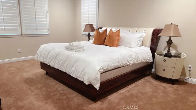 a bed sitting in a bedroom next to a window