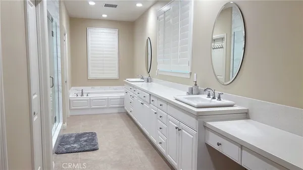 a bathroom with a double vanity sink mirror and bathtub