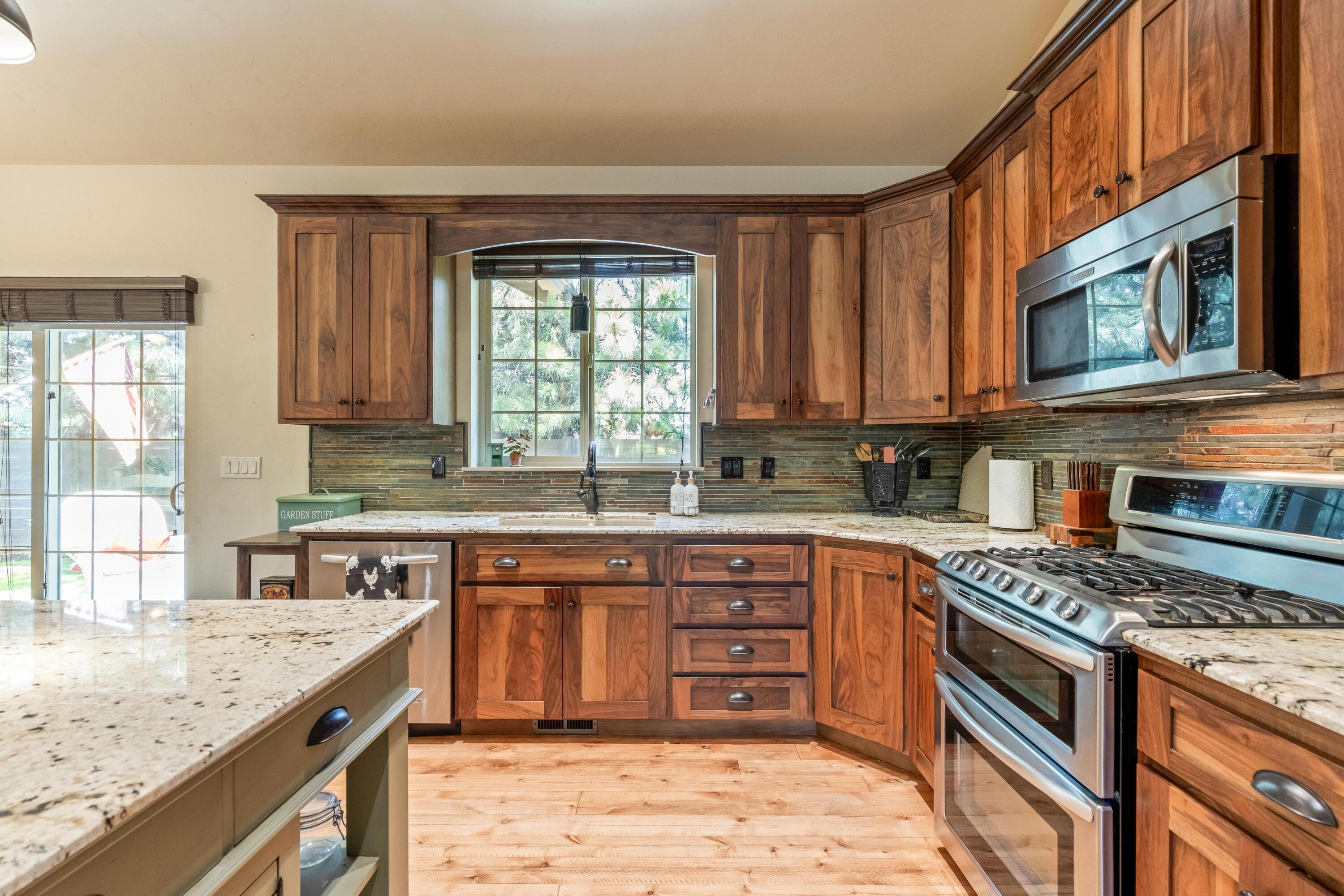 210 Northwest Saddle Ridge Loop Prineville, OR 97754 - Photo 10 of 38 a kitchen with stainless steel appliances granite countertop a stove sink and cabinets