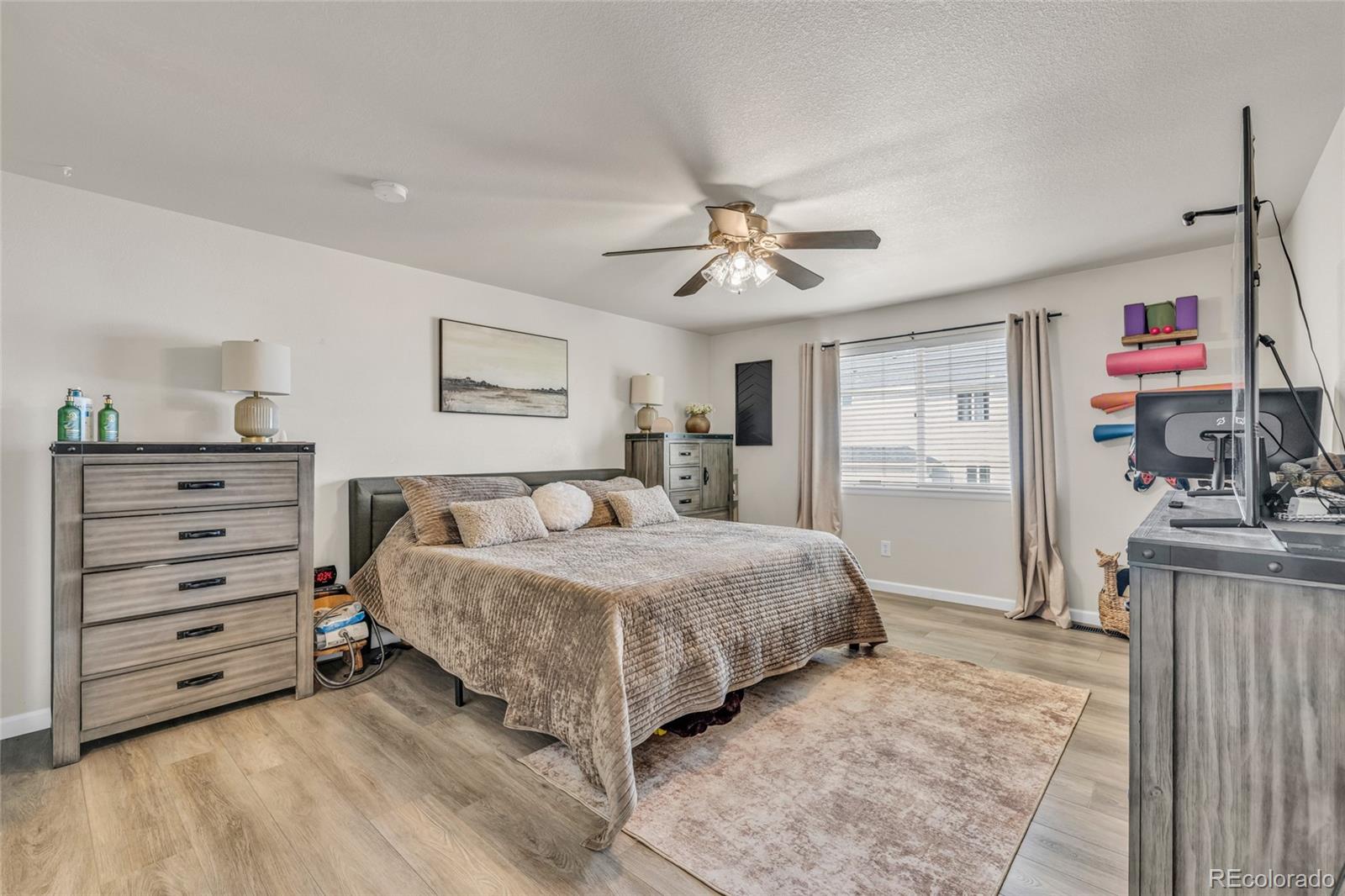 6132 Graden Street Frederick, CO 80530 - Photo 11 of 28 a spacious bedroom with a bed and a chandelier