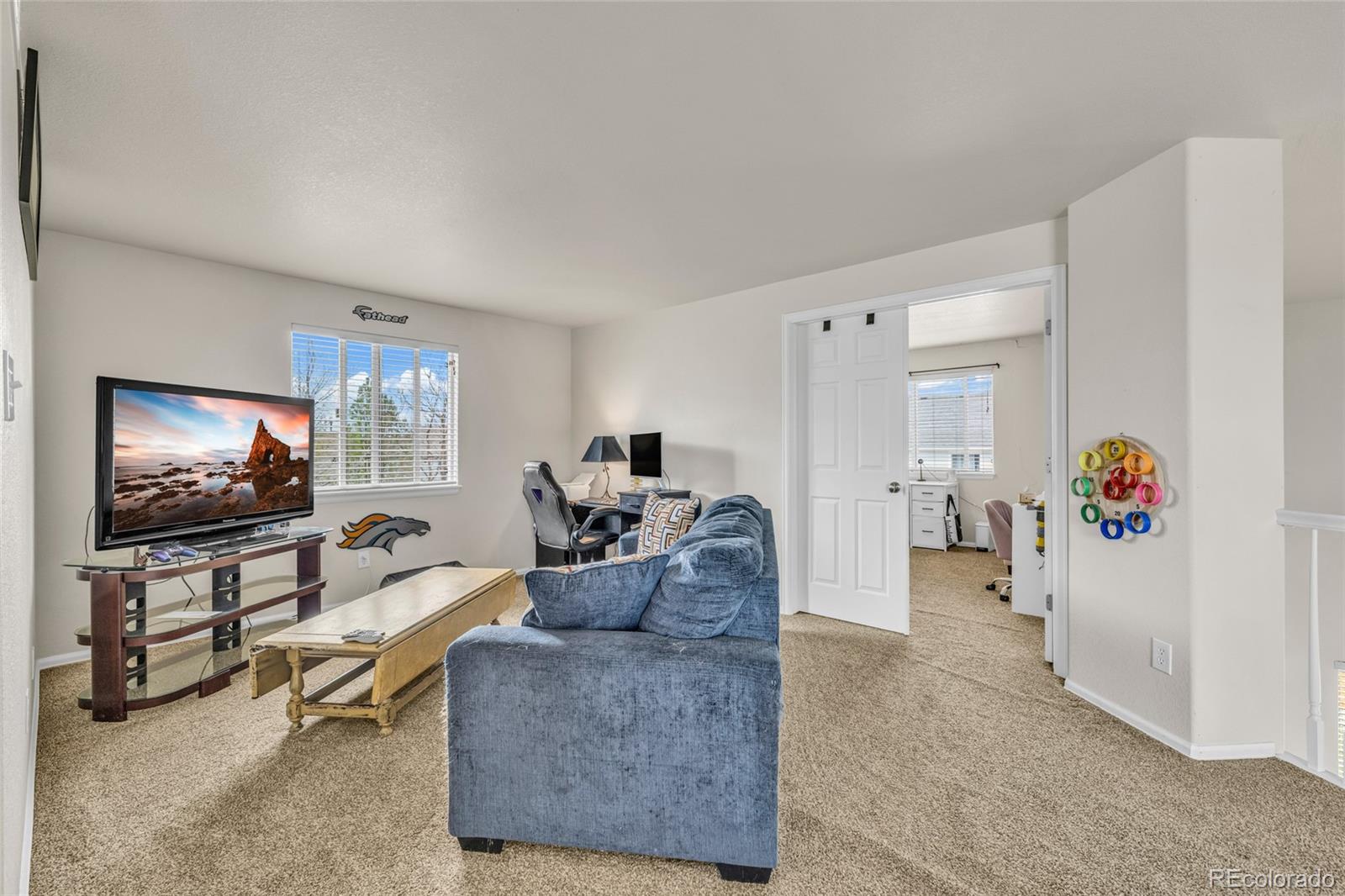 6132 Graden Street Frederick, CO 80530 - Photo 17 of 28 a living room with furniture and a flat screen tv