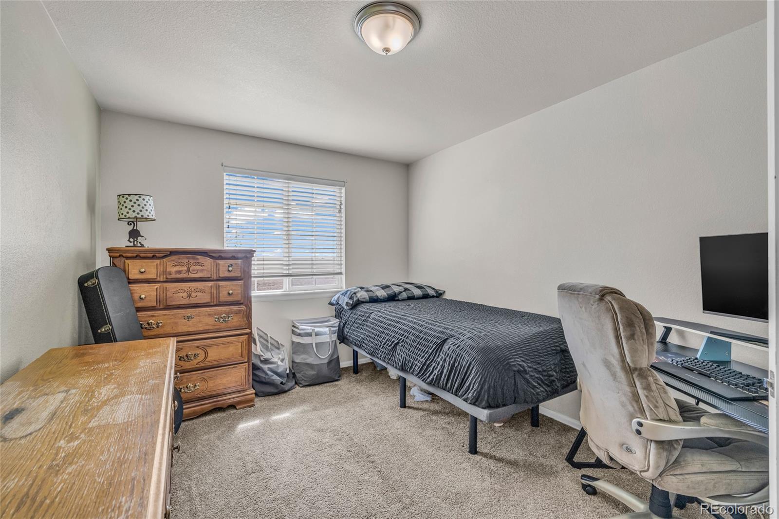 6132 Graden Street Frederick, CO 80530 - Photo 20 of 28 a bedroom with a bed and a chair