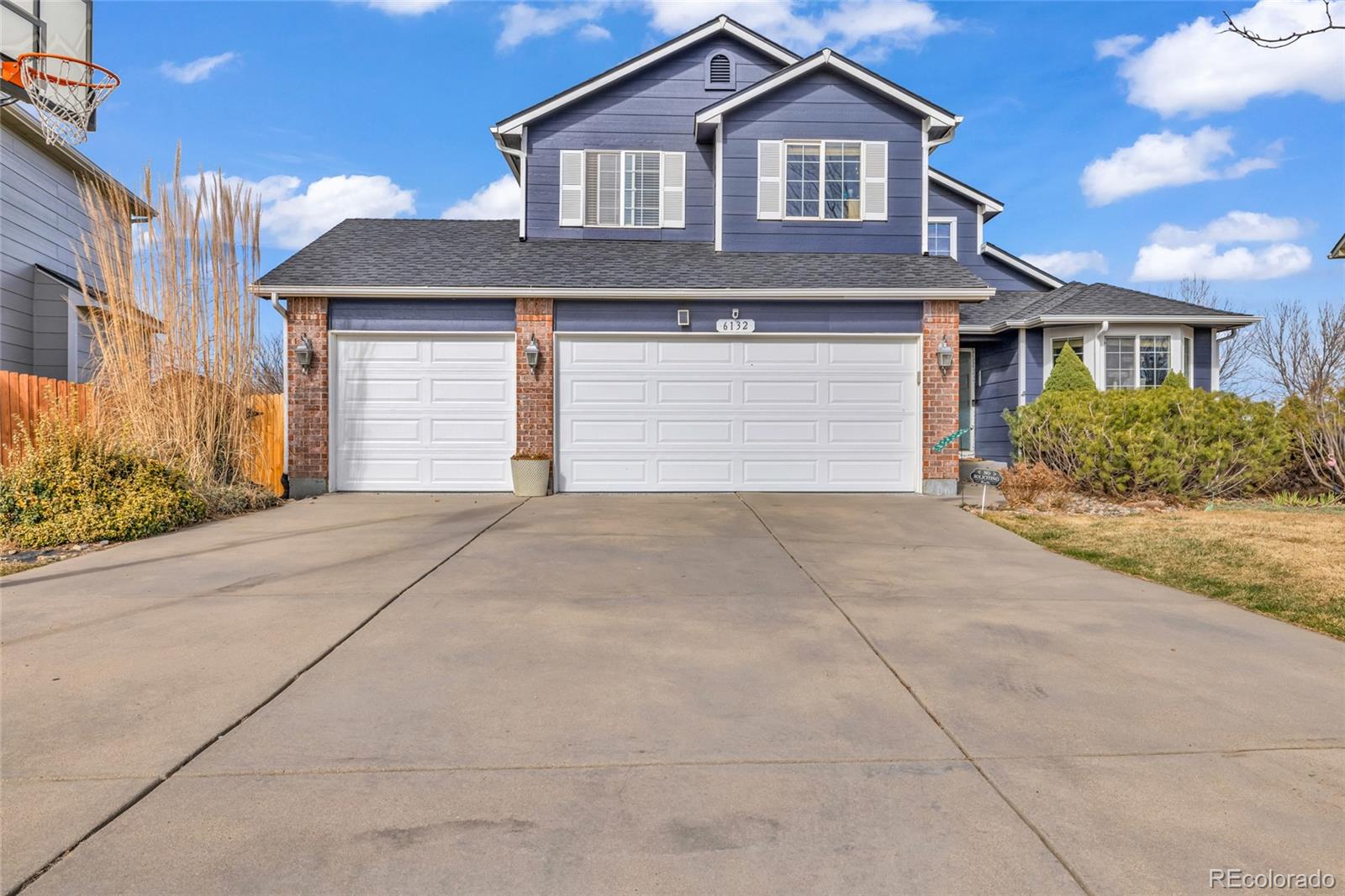 6132 Graden Street Frederick, CO 80530 - Photo 2 of 28 a front view of a house with a yard and garage