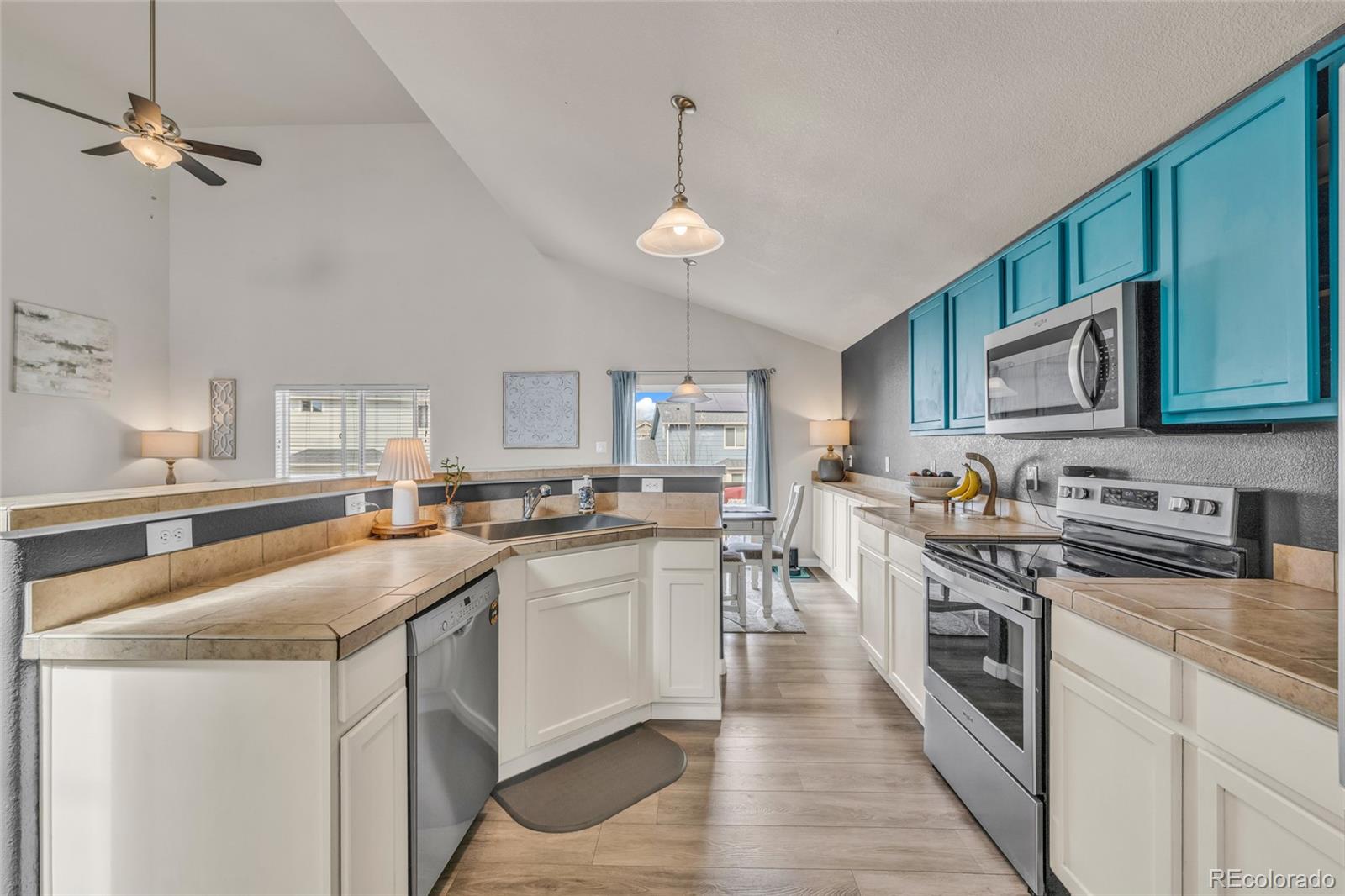 6132 Graden Street Frederick, CO 80530 - Photo 3 of 28 a kitchen with stainless steel appliances a sink stove cabinets and microwave