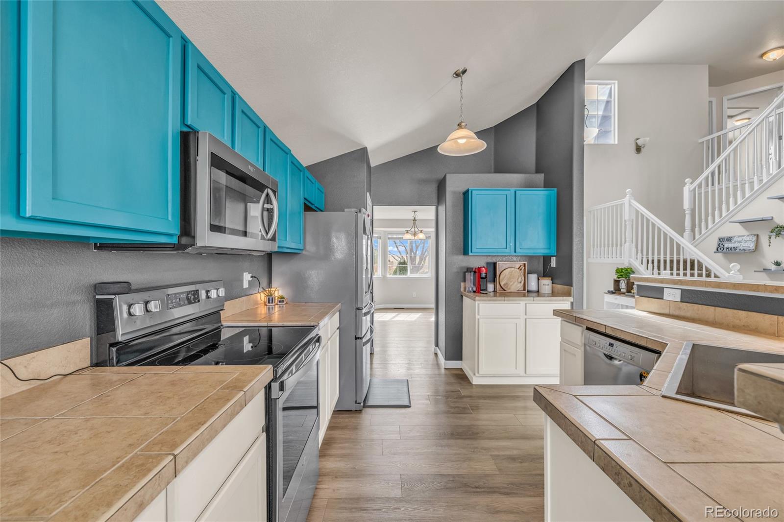 6132 Graden Street Frederick, CO 80530 - Photo 4 of 28 a kitchen with stainless steel appliances granite countertop a stove top oven a sink dishwasher and a refrigerator with wooden floor