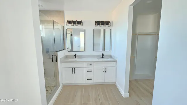 a spacious bathroom with double vanity and a mirror