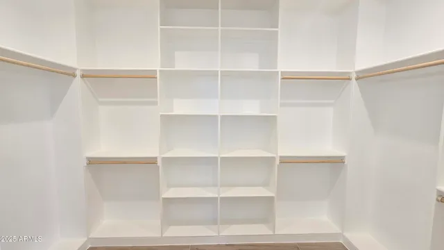 a view of walk in closet with empty racks