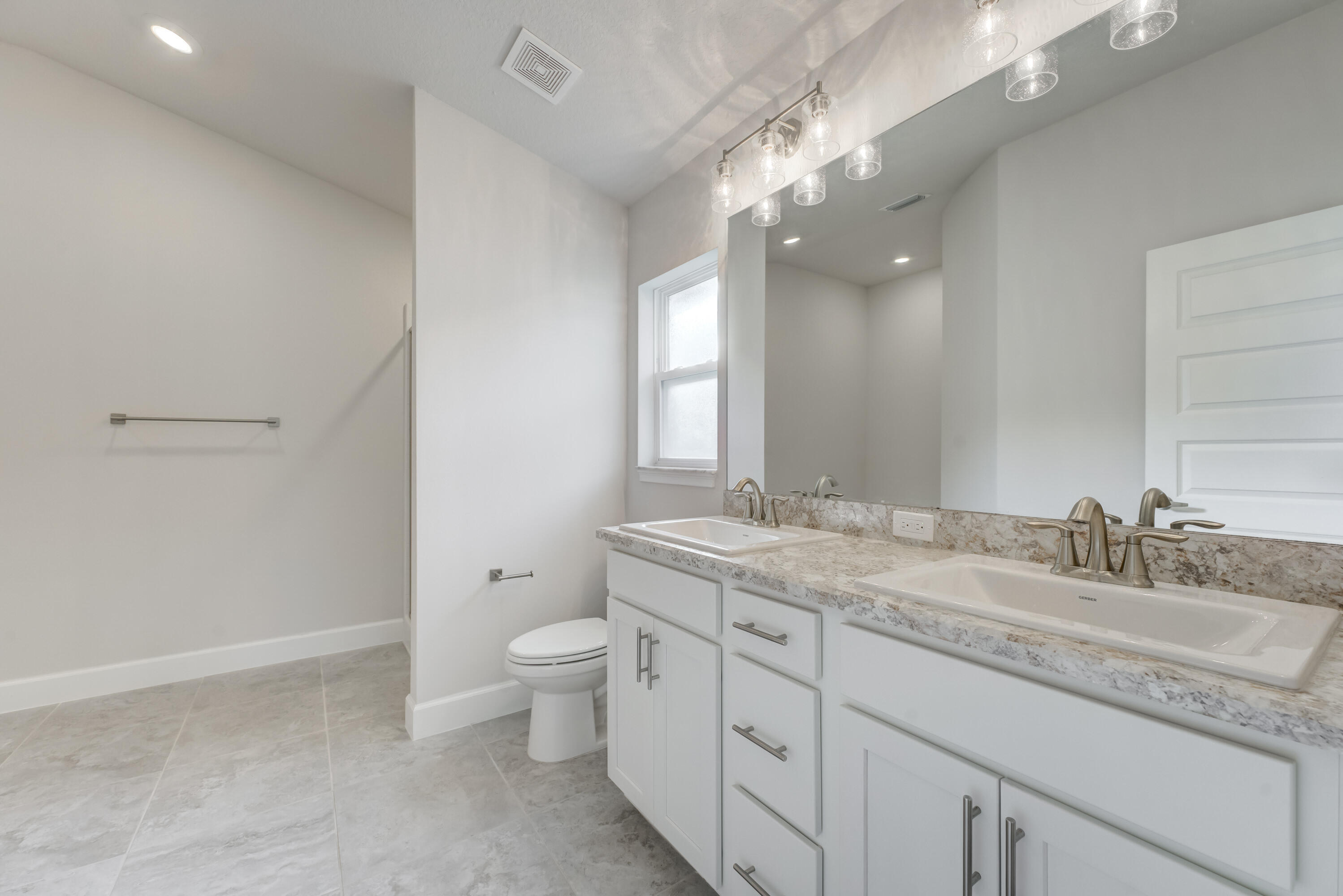 5327 Vespera Street Fort Pierce, FL 34951 - Photo 14 of 27 a bathroom with a granite countertop sink a toilet and a mirror