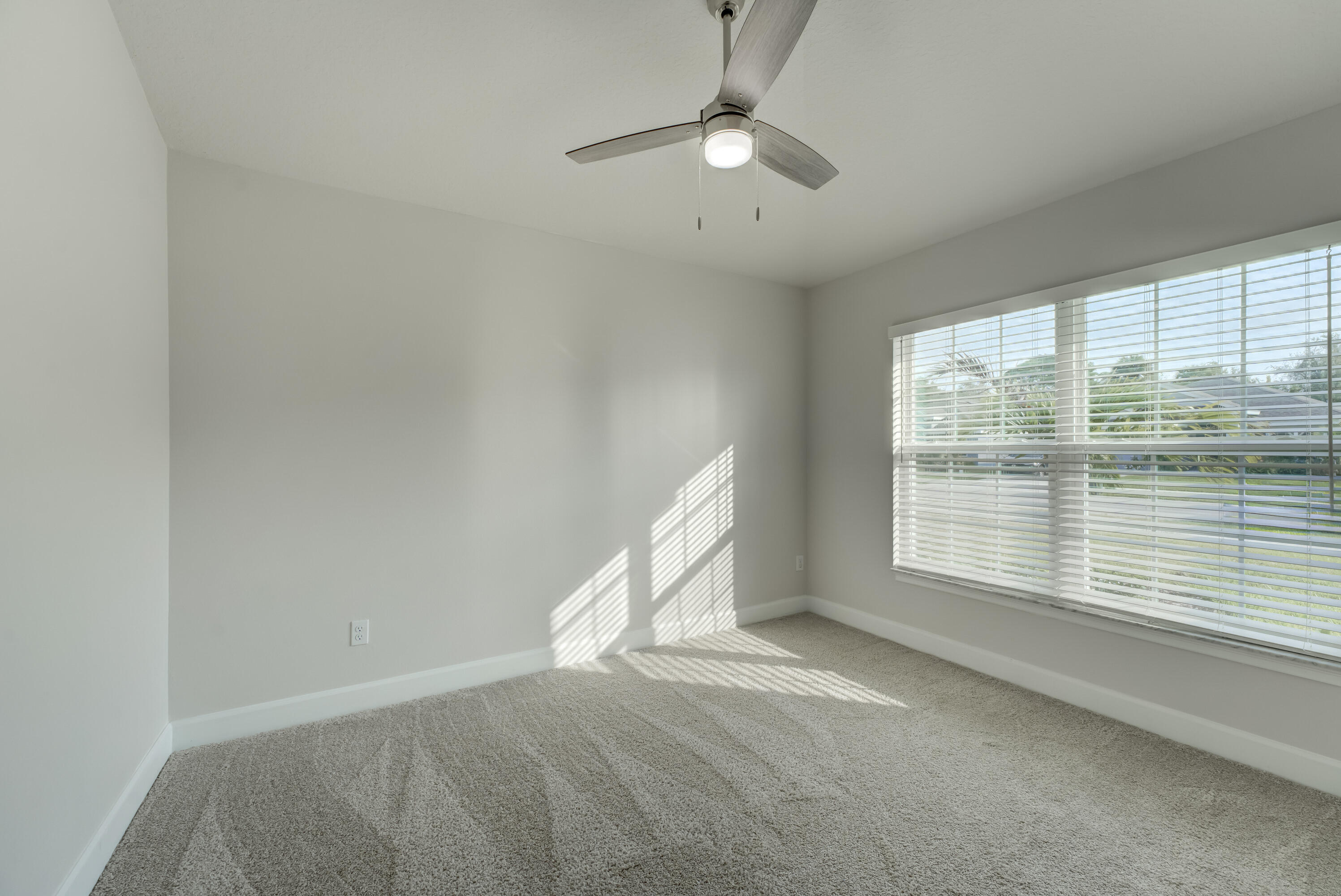 5327 Vespera Street Fort Pierce, FL 34951 - Photo 19 of 27 an empty room with chandelier fan and windows