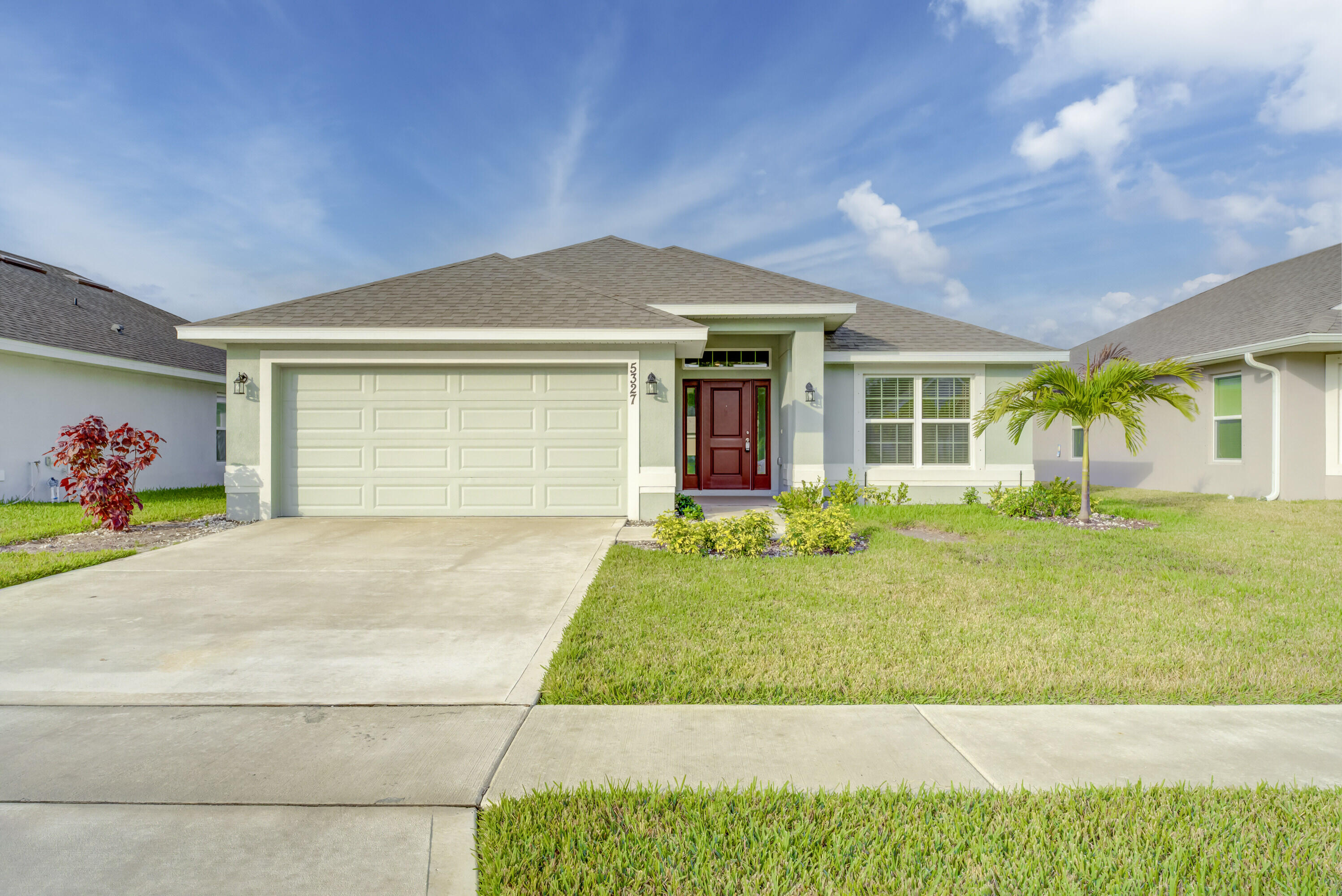 5327 Vespera Street Fort Pierce, FL 34951 - Photo 2 of 27 a front view of a house with garden
