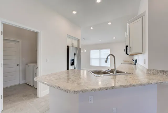 a kitchen with granite countertop a sink and a refrigerator