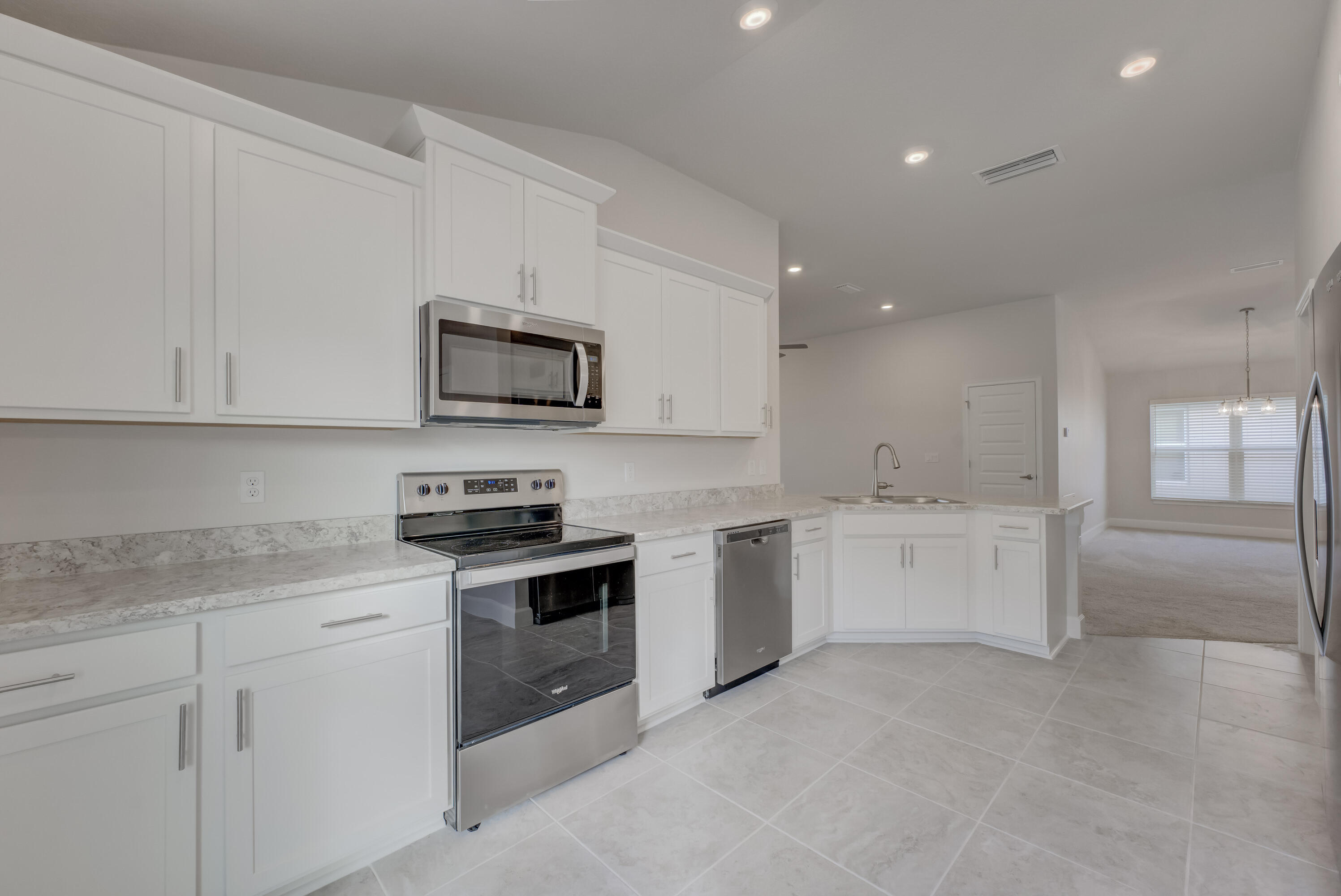 5327 Vespera Street Fort Pierce, FL 34951 - Photo 9 of 27 a kitchen with granite countertop white cabinets and stainless steel appliances