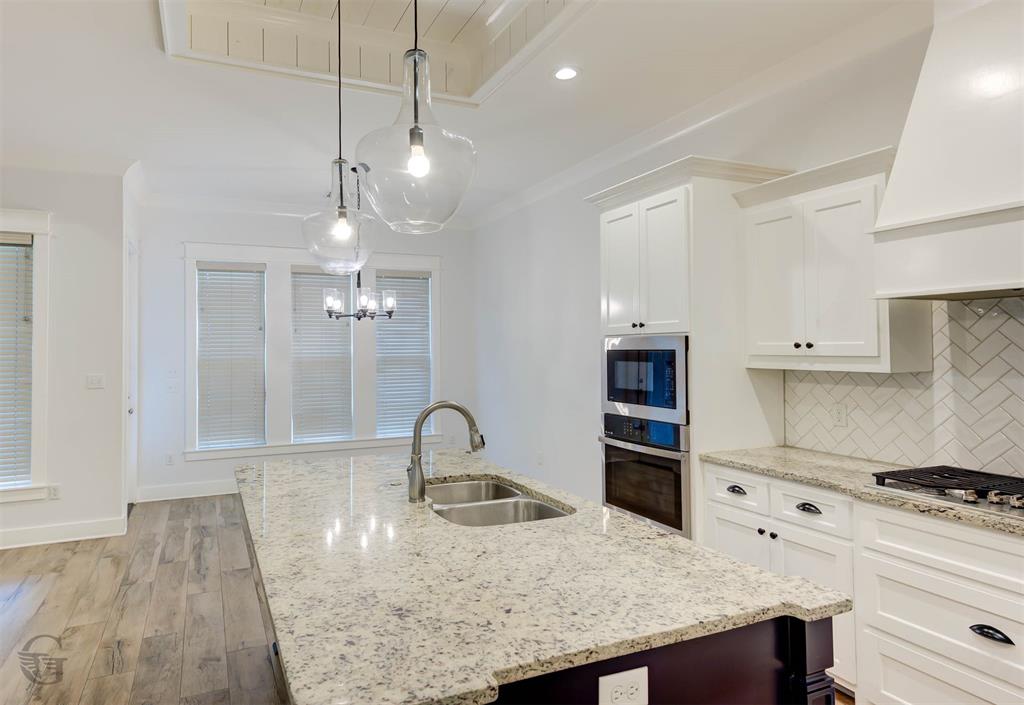 605 Meridian Way Benton, LA 71006 - Photo 9 of 29 Kitchen featuring a central island with a double basin sink, light-toned countertop, and modern pendant lighting