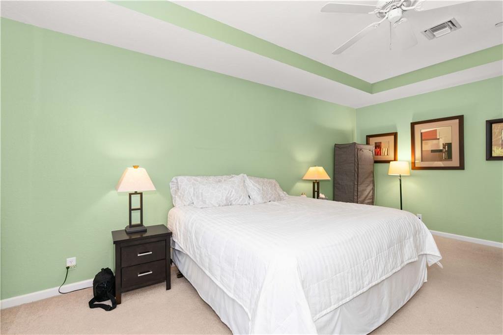 163 Southwest Walking Path Stuart, FL 34997 - Photo 23 of 37 a bedroom with a bed and a lamp