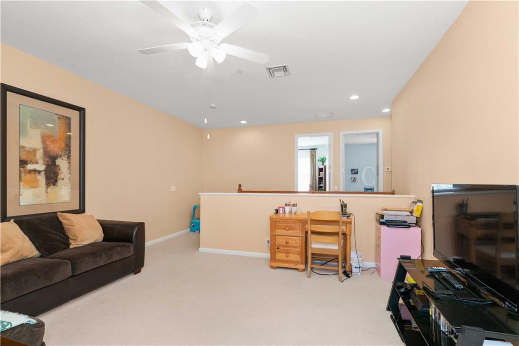 163 Southwest Walking Path Stuart, FL 34997 - Photo 25 of 37 a living room with furniture and a flat screen tv