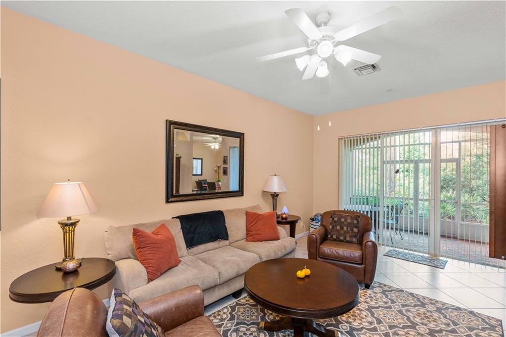 163 Southwest Walking Path Stuart, FL 34997 - Photo 4 of 37 a living room with furniture and a lamp