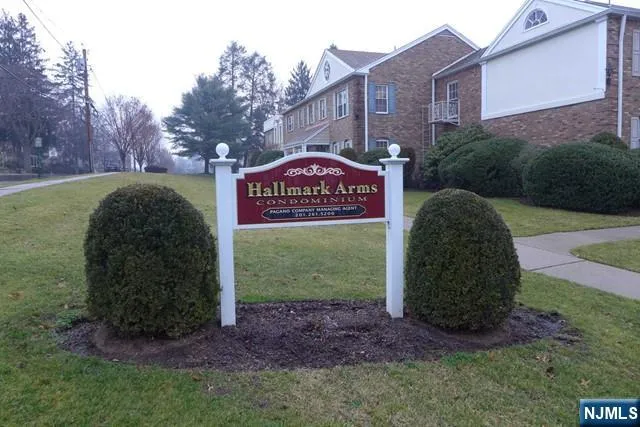 a sign board with a small yard and trees