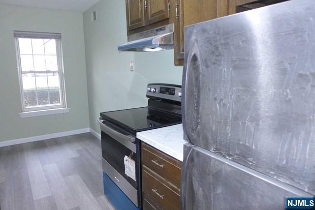 350 Maple Avenue, Unit 1 Oradell, NJ 07649 - Photo 3 of 9 a kitchen with a wooden floor and a stove