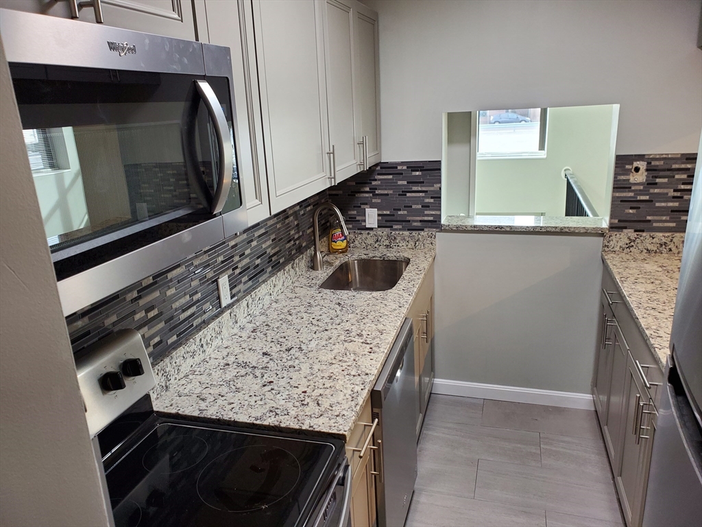 33 Brainerd Road, Unit 112 Boston, MA 02134 - Photo 1 of 23 a kitchen with granite countertop a sink and a stove