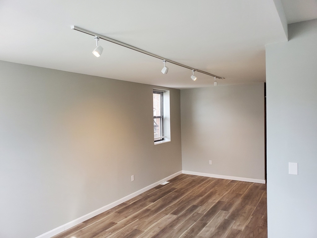 33 Brainerd Road, Unit 112 Boston, MA 02134 - Photo 17 of 23 an empty room with wooden floor and windows