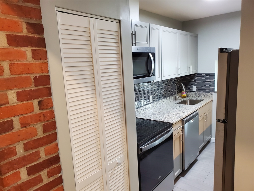 33 Brainerd Road, Unit 112 Boston, MA 02134 - Photo 5 of 23 a kitchen with a sink and a stove top oven