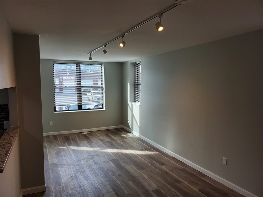 33 Brainerd Road, Unit 112 Boston, MA 02134 - Photo 6 of 23 an empty room with wooden floor and windows