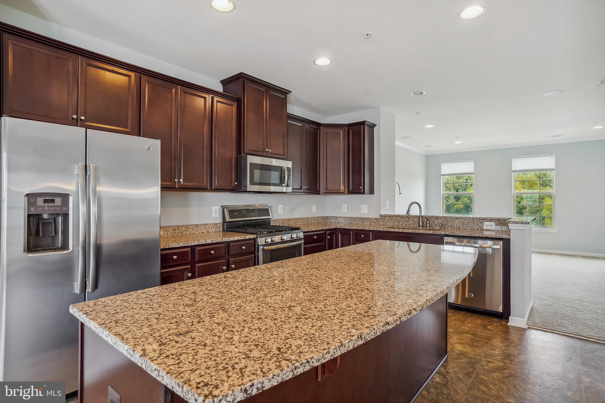 5934 Jefferson Commons Way Frederick, MD 21703 - Photo 11 of 27 a kitchen with stainless steel appliances granite countertop a sink refrigerator and microwave