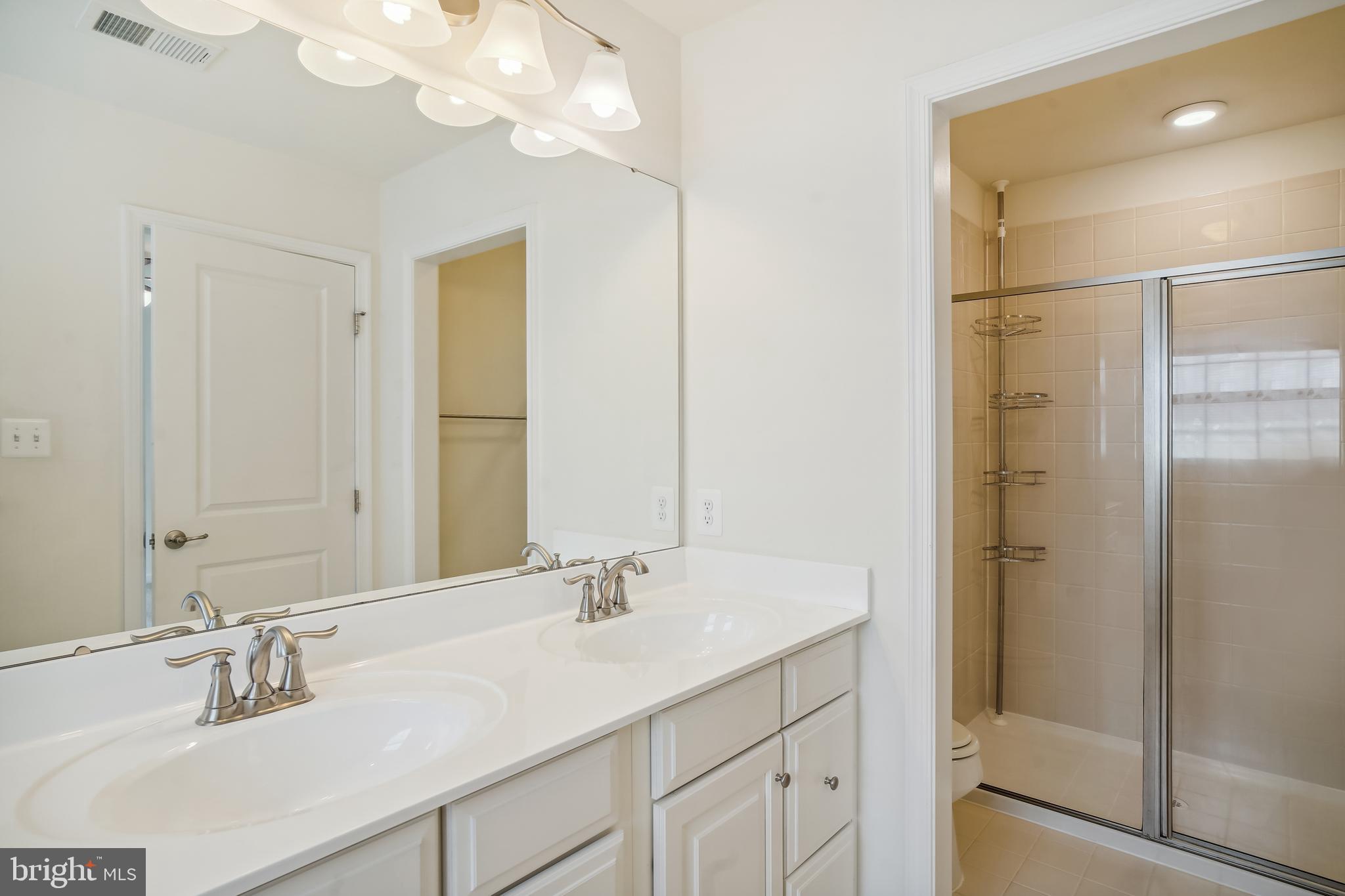 5934 Jefferson Commons Way Frederick, MD 21703 - Photo 13 of 27 a bathroom with a double vanity sink mirror and shower