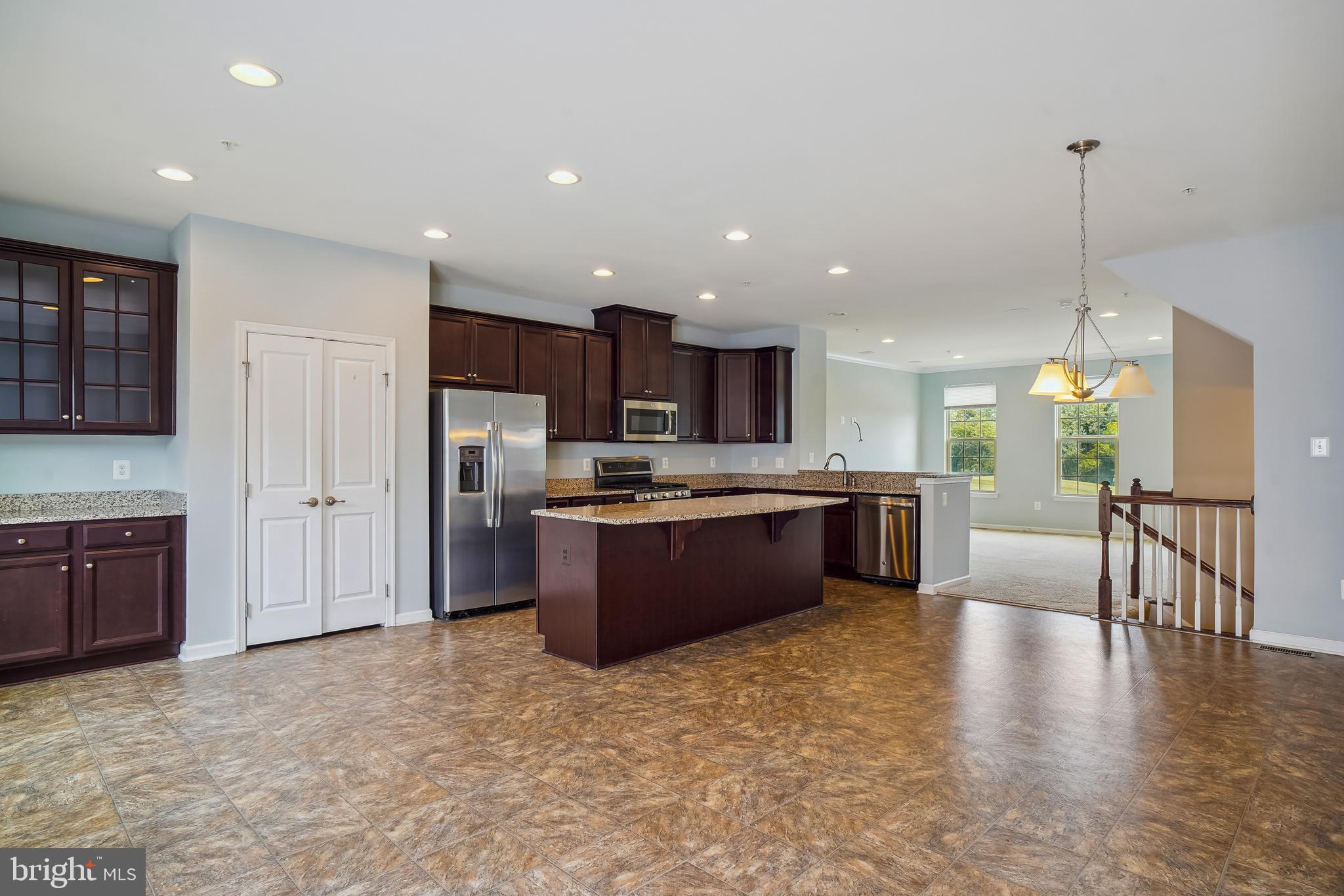 5934 Jefferson Commons Way Frederick, MD 21703 - Photo 10 of 27 a large kitchen with stainless steel appliances granite countertop a refrigerator a sink dishwasher a oven and a large countertops with wooden floor