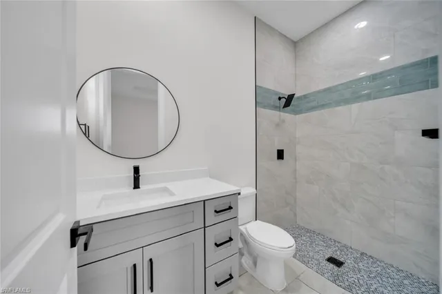 a bathroom with a granite countertop toilet sink and mirror