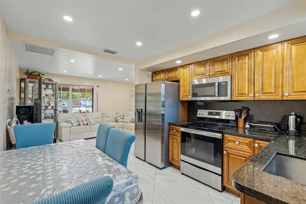 a kitchen with stainless steel appliances granite countertop a refrigerator stove top oven a sink and dishwasher
