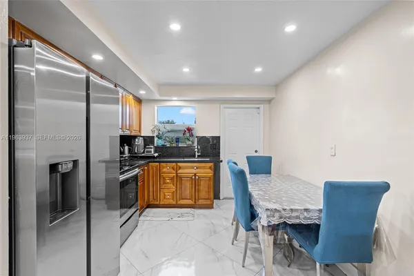 a kitchen with stainless steel appliances kitchen island granite countertop a refrigerator and a stove top oven