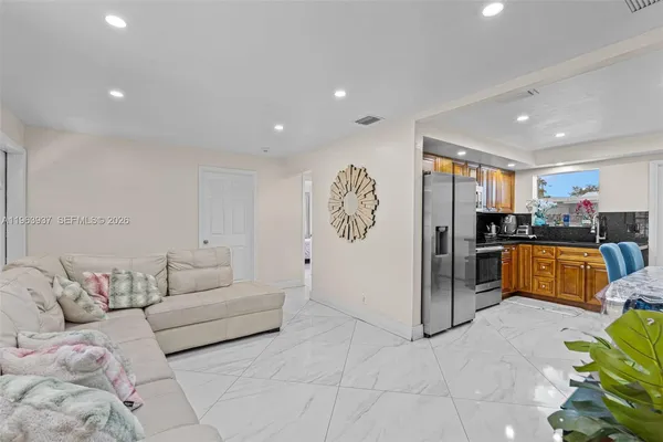 a living room with furniture and kitchen view
