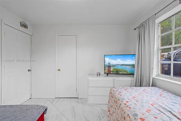 a bedroom with a bed and a flat screen tv