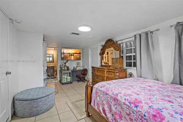 a bedroom with a large bed and a flat tv screen