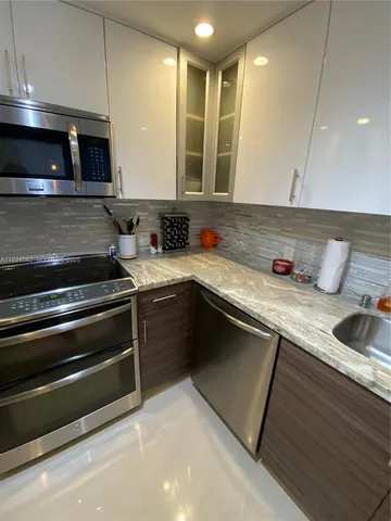 a kitchen with a sink and stove top oven