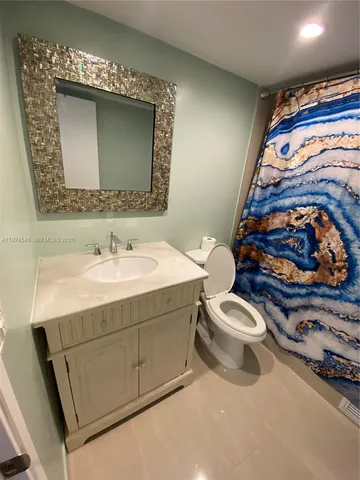 a bathroom with a sink mirror vanity and toilet