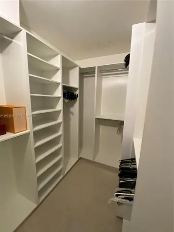 a view of walk in closet with empty racks