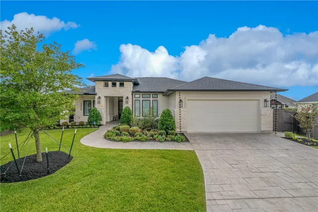 a front view of a house with a garden and yard