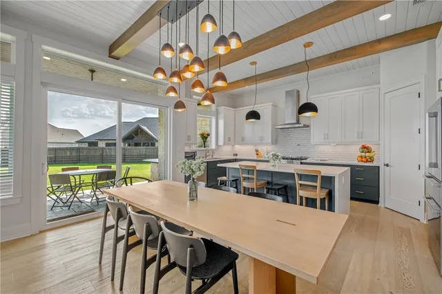 a kitchen with a table chairs and wooden floor