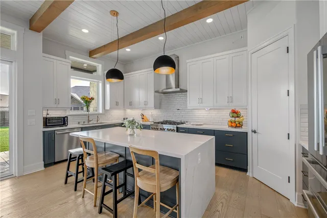 a kitchen with stainless steel appliances a sink stove and white cabinets