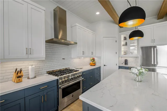 a kitchen with stainless steel appliances granite countertop a sink a stove and a wooden floors