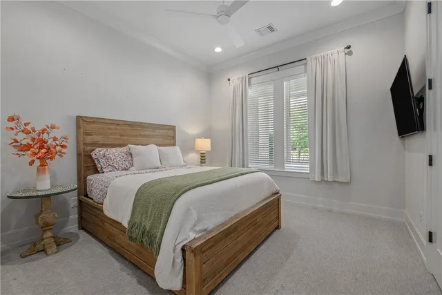 a spacious bedroom with a bed and a flat screen tv