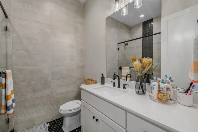 a bathroom with a sink vanity mirror and toilet