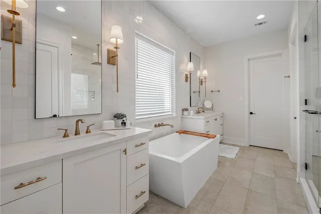 a bathroom with a tub sink and mirror