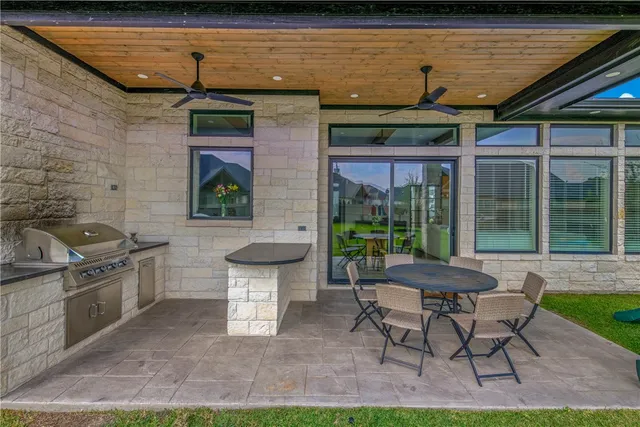 a patio with a table and chairs and potted plants