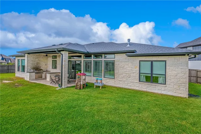 a view of a house with a yard and sitting area