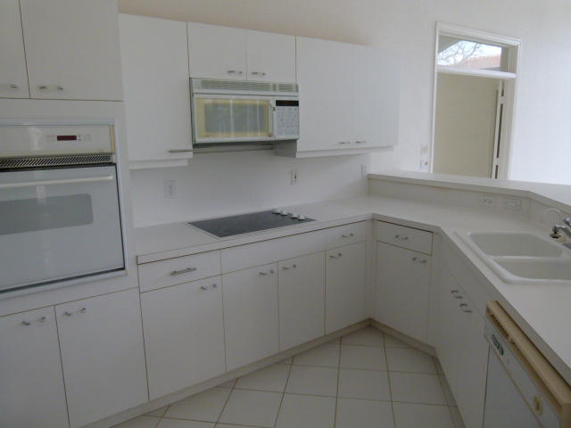 7901 Dorchester Road Boynton Beach, FL 33472 - Photo 4 of 14 a kitchen with white cabinets appliances and sink