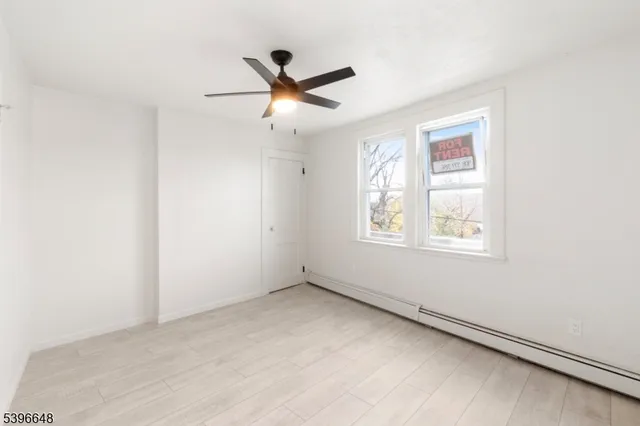 a view of empty room with window and ceiling fan
